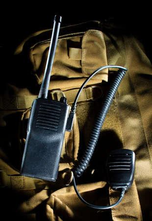 Two way radio and microphone on a brown backpackの写真素材