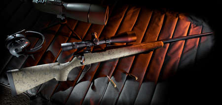 Bolt action rifle on a shooting mat with hearing protection and spotting scopeの写真素材