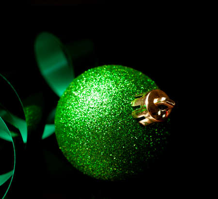 Holiday ornament with green ribbon on a black backgroundの写真素材