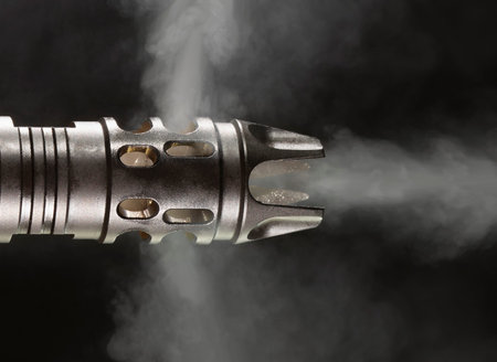 AR-15 muzzle brake on black with smoke pouring out the sides