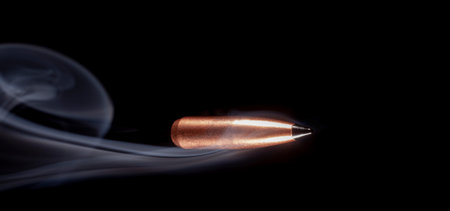 Polymer tipped bullet racing across a black background with smoke trailing behind