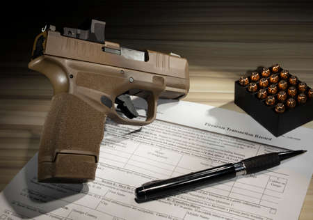 Public domain form 4473 for the purchase of the pistol with ammo on the tableの写真素材