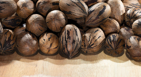 Pecans in their shell on a wood table