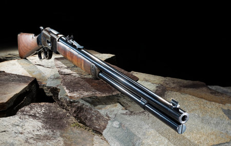 Copy space on the black background above a wild west lever action rifle with finely blued metal and...