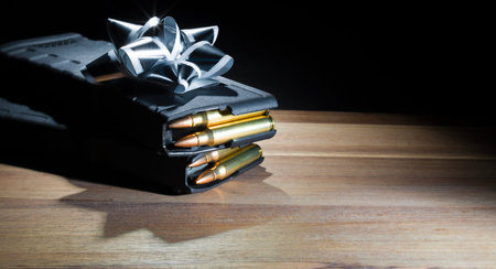 Two assault rifle magazines that are high capacity and fully loaded under a silver bow as a gift fo...