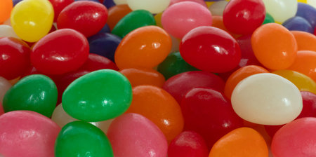 Brightly colored assortment of jelly bean candies in red, orange, green, yellow, purple and white...