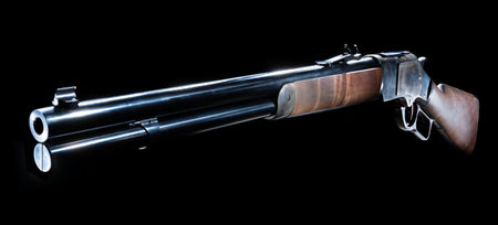 Traditional Old West style lever action rifle with a wood stock and color casehardened receiver on a...