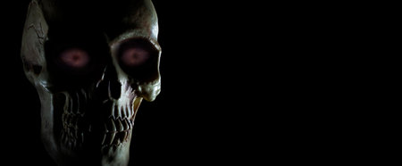 Glowing purple eyes on a human skull with copy spaceの写真素材
