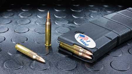 I voted sticker on an AR-15 magazine loaded with cartridges and an I voted sticker on the outside.