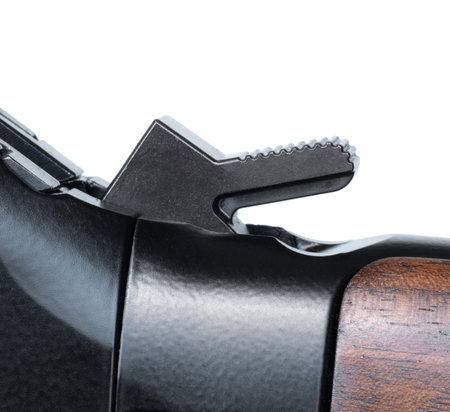 Hammer on a lever action rifle with wood furniture cocked and ready to fire seen up close and isolated on a white background.の写真素材