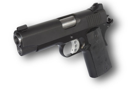 Shadow behind a handgun chambered for 45 caliber ammunitionの写真素材