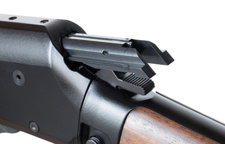 Hammer being cocked as the bolt on a .22 caliber rimfire lever action rifle with a wood stock that is isolated in a white background.の写真素材