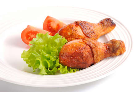 Grilled chicken leg with tomato on white backgroundの写真素材