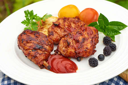 Grilled chicken Legs with spices and herbs on a plateの写真素材