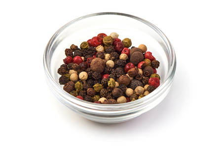 Pepper mix. Black, red and white peppercorns in a transparent cup, isolated on white background. Close-up.の写真素材