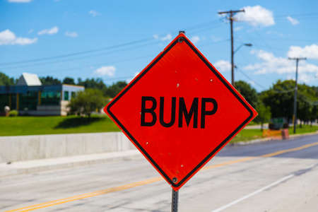 A bump hazard sign warning there is a bump in the roadway.の写真素材