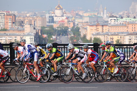Participants and athletes riding bikes, mass start on the bridge in city centerのeditorial素材