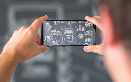 Chinese smartphone Vivo NEX in hands in front of a black wall with chalk drawingsのeditorial素材