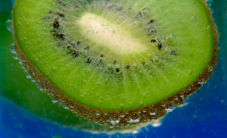 Kiwi And Bubbles In A Glass On Blue Backgroundの写真素材