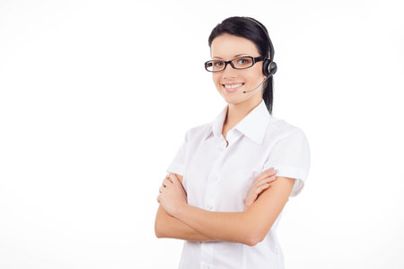 Customer service representative. Confident young woman in headset smiling and keeping her arms...