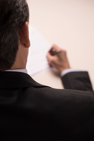Contract signing. Rear top view of man in formalwear signing a documentの写真素材