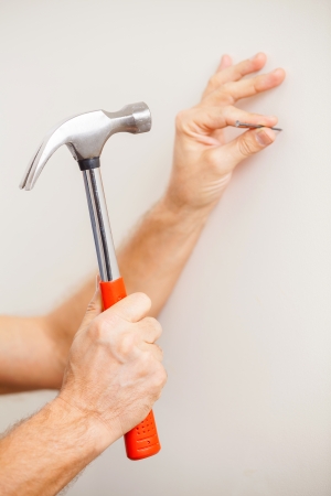 Hammering a nail. Close-up of man hammering a nail の写真素材