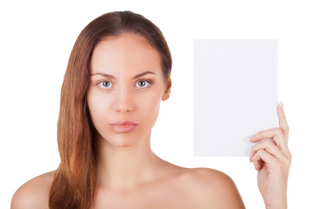 Portrait of beautiful young woman with half face make-up holding a copy space and looking at camera while standing isolated on white backgroundの写真素材