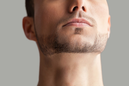 Handsome man. Cropped image of handsome young beard man isolated on grey backgroundの写真素材