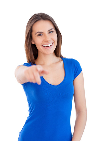 Yes you! Beautiful young smiling woman looking at camera and pointing you while standing isolated on whiteの写真素材