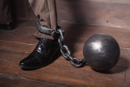 businessman leg with metal shacklesの写真素材
