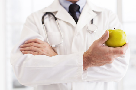 doctor in white uniform holding an appleの写真素材