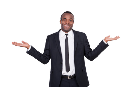 Hard choice. Cheerful young African man in formalwear gesturing and smiling while standing isolated on white background の写真素材