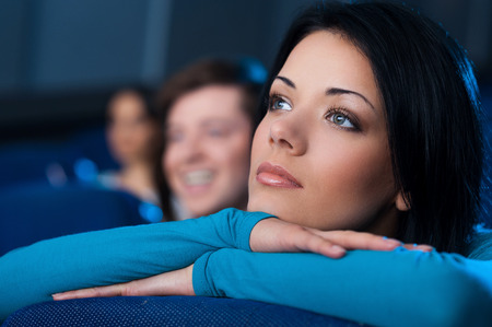 Woman at the cinema. Beautiful young woman watching movie at the cinemaの写真素材