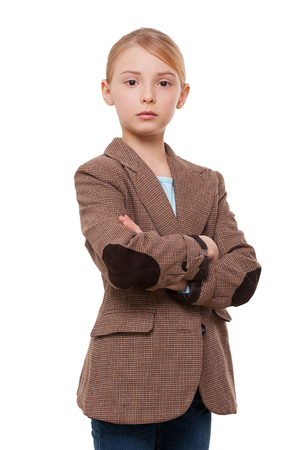 Confident little leader. Confident little girl in formalwear holding arms crossed while standing isolated on whiteの写真素材