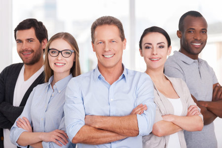 Confident business team. Group of cheerful business people in casual wear standing close to each...