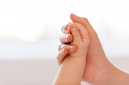 I am always near. Close-up of mother hand holding hand of her little babyの写真素材