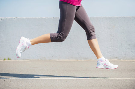 Burning the miles away.  Side view close-up image of woman running outdoors 