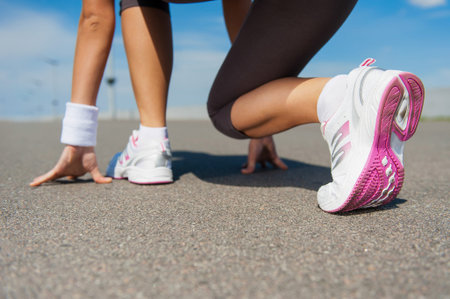 Getting ready to run.  Close-up image of woman in sports shoes standing in starting line 