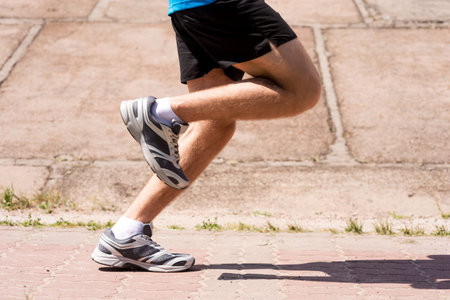 Burning the miles away.  Side view close-up image of man running outdoors の写真素材