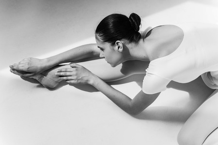 Working hard to be the best. Top view of beautiful young ballerina doing stretching exercisesの写真素材
