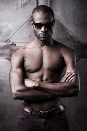 Cool handsome. Handsome young shirtless African man in sunglasses keeping arms crossedの写真素材