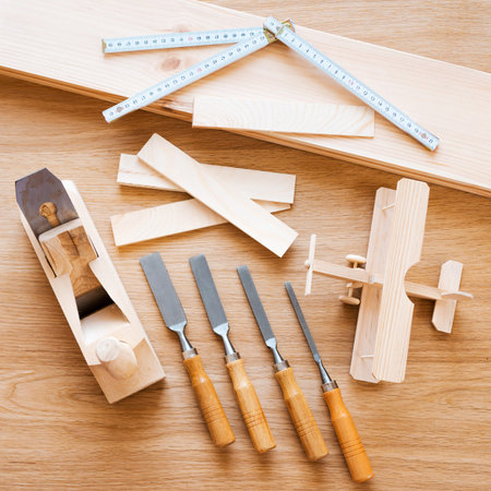 Wood work. Top view of diverse working tools for wood industry and toy plane laying on the wood...