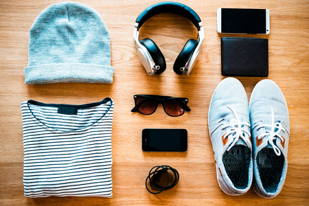 Youth collection. Top view of clothing and diverse personal accessory for teenagers laying on the wooden grainの写真素材