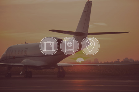 Good time for travelling. Digitally composed icon set over a picture of private jet landing in sunsetの写真素材