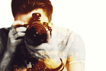 Sunset shot. Digitally composed close-up picture of young photographer looking threw his camera over...