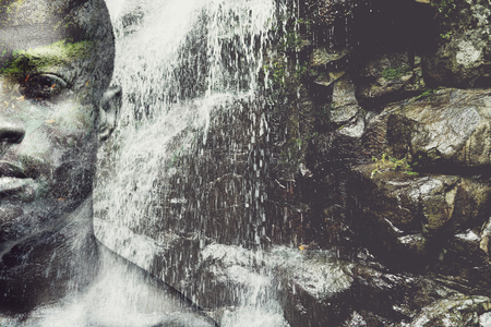 Energy inside him. Digitally composed half full face picture of handsome young African man over the picture of waterfallの写真素材