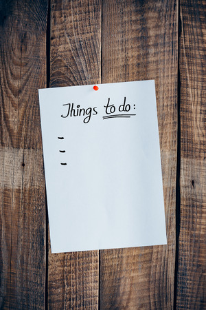 Things to do. Close-up of vintage wood background with pinned sheet of paper with to do list on itの写真素材