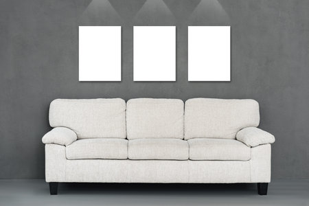 Perfect copy spaces. Mockup of three canvases hanging on the wall with sofa on foreground