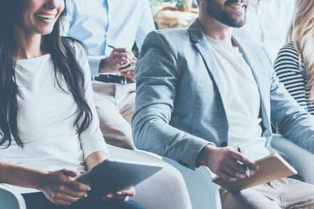 Business conference concept. Close-up of cheerful young business people sitting on conference...