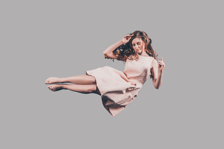 Beauty in air. Studio shot of attractive young woman hovering in airの写真素材